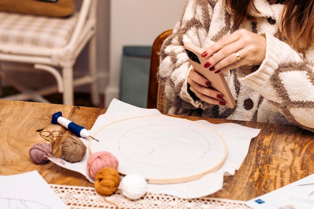 Osoba haftująca przy stole